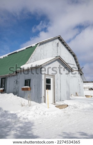 White barn with green roof, old wood in the winter, Quebec, Canada Royalty-Free Stock Photo #2274534365