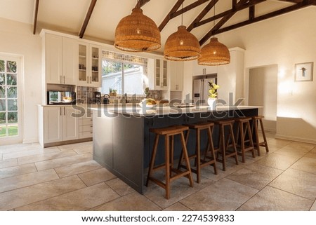 General view of modern kitchen with countertop, chairs and kitchen equipment. House interior and design concept.