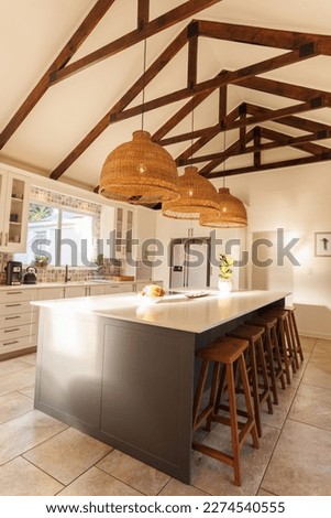 General view of modern kitchen with countertop, chairs and kitchen equipment. House interior and design concept.