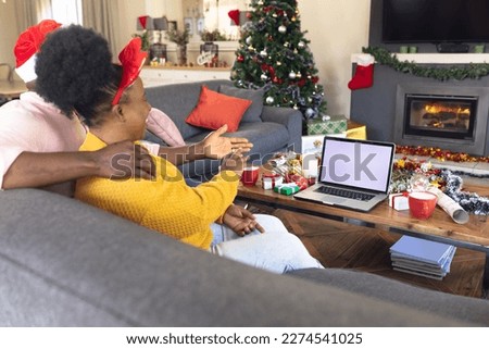 African american couple having face time and using laptop with copy space. Christmas, family time and celebration concept using technology.