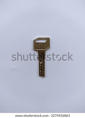 A small iron door key that is placed on top of a white piece of paper