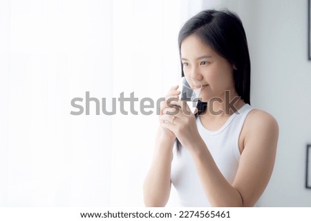 Beautiful young asian woman drinking glass of water mineral pure with fresh and happy at home, asia female drinking beverage for healthcare and weightloss, one person, lifestyles concept. Royalty-Free Stock Photo #2274565461