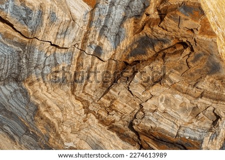 Abstract geologic background featuring a stunning display of natural rock formations with intricate layers and earthy colors creating a unique and captivating visual texture. Royalty-Free Stock Photo #2274613989