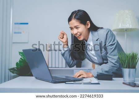 Young Asia business woman working with annual summary report and laptop to planner analyze data of balance sheet charts, bookkeepers female people concept. Using laptop