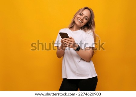 a girl with a gadget in her hands makes an order on the Internet on a yellow background