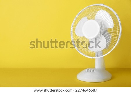 Electric fan on yellow background Royalty-Free Stock Photo #2274646587