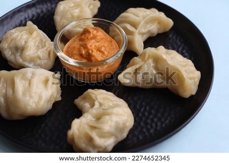 Momos, Dumplings served with sauce Royalty-Free Stock Photo #2274652345