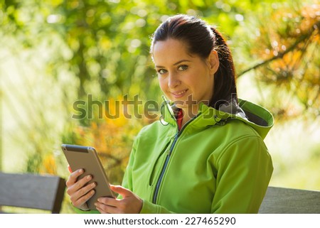 Young woman with tablet in autumn park, portrait photo.