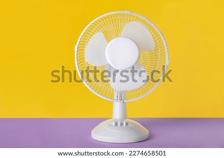 Electric fan on yellow background Royalty-Free Stock Photo #2274658501