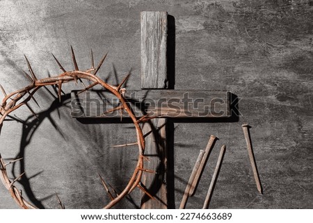 Crown of thorns with wooden cross and nails on dark background. Good Friday concept