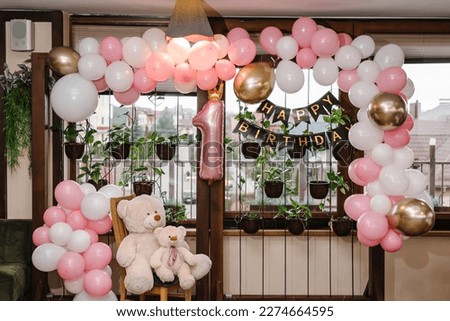 Arch decorated with pink, brown, white, and golden balloons. Birthday arch for 1 year and a background photo wall. Reception at a birthday party in a restaurant. Royalty-Free Stock Photo #2274664595
