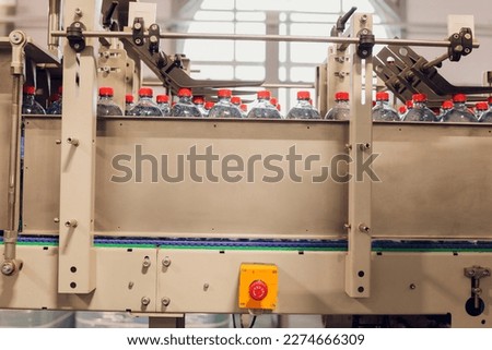 Production of Technical Fluids. Industrial Automated Mechanism for Prepare Plastic Bottles. Chemicals Production Line. Row of Plastic Bottles Moves along the Converyor Closeup
