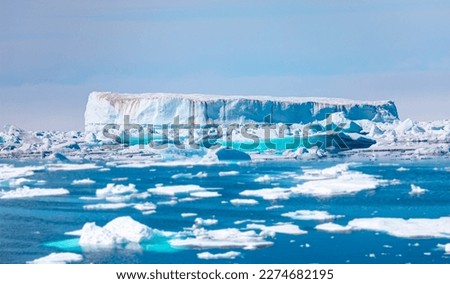 Melting icebergs by the coast of Greenland, on a beautiful summer day - Melting of a iceberg and pouring water into the sea - Greenland Royalty-Free Stock Photo #2274682195