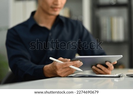 Selective focus on hands. Cropped image of businessman holding stylus pen and using digital tablet at office desk Royalty-Free Stock Photo #2274690679