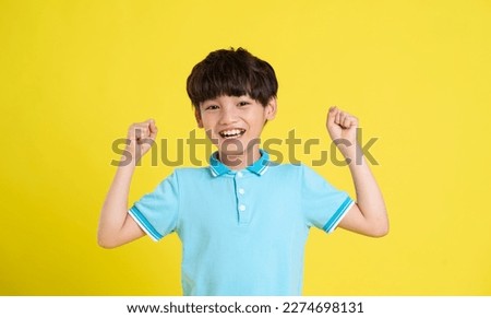 portrait of an asian boy posing on a yellow background Royalty-Free Stock Photo #2274698131