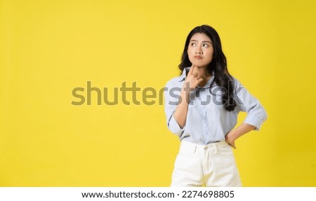 portrait of beautiful asian girl posing on yellow background
