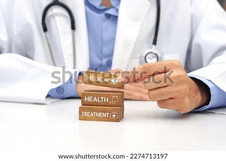 Hand holding a wooden block cube the top one with word and icon symbol. Medical and health concept.