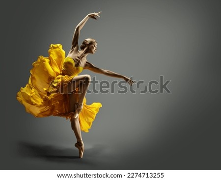 Ballerina in Yellow Chiffon Dress dancing over Gray Background. Ballet Dancer jumping in Air in Silk Gown. Modern Dance Graceful Woman performing in flying Skirt