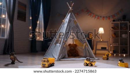 empty children's bedroom in the evening with toys and tent set up. Kindergarten block during night time  Royalty-Free Stock Photo #2274715863