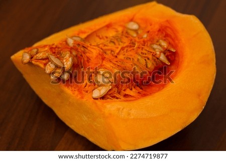 Yellow pumpkin on a wooden background. Pumpkin seeds. Pumpkin pulp. Cooking food from fresh vegetables from the market. Healthy eating. Ingredients for cooking. Cooking pumpkin soup