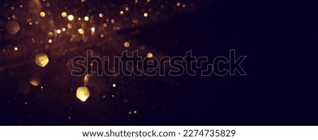 background of abstract glitter lights. gold and black. de focused