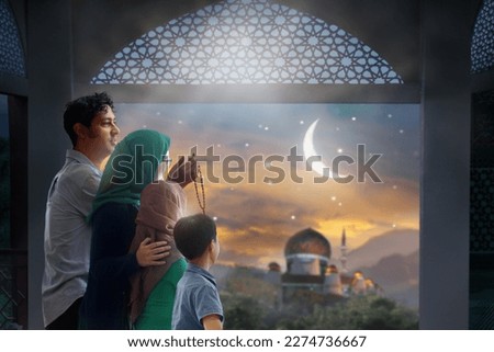 Ramadan Kareem greeting. Family at window looking at Islamic city with mosque skyline, crescent moon and stars. Muslim parents and children pray. Mother, father and kids celebrate end of fasting.  Royalty-Free Stock Photo #2274736667