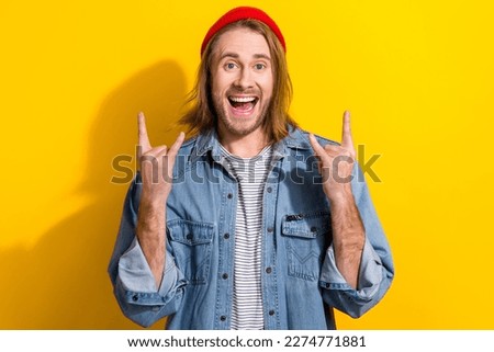 Photo of funky cool man wear denim jacket showing hard rock signs isolated yellow color background