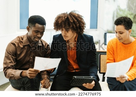 Young colleagues of a startup analyze data together and study strategies Royalty-Free Stock Photo #2274776975