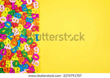 Colorful Wooden Numbers on Yellow Paper Background. Back to school concept.
