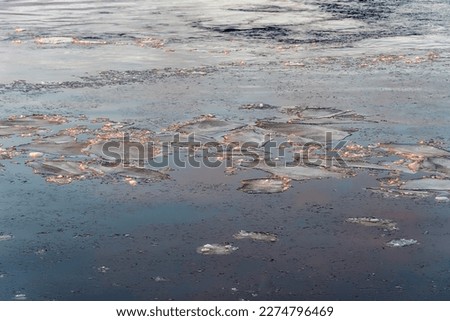 Ice floes in the water, illuminated by the setting sun, as a natural background.