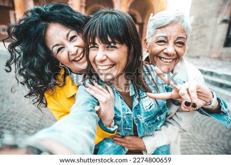 Three senior women taking selfie photo with smart mobile phone device outside - Happy aged people having fun together walking on city street - Life style concept with mature females hanging out 