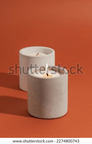 A lighted candle. Aromatic premium soy candles in gray concrete jar. Poster banner for candle shop, beauty, spa
