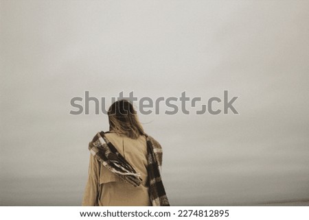 Standing on the shore of the Baltic Sea, a solitary figure gazes out towards the horizon. This photo captures a moment of quiet introspection. Royalty-Free Stock Photo #2274812895