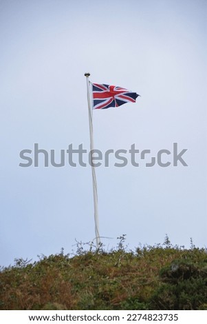 Lundy Devon UK, October 12th 2021. A Union Jack Flag on a tall flagpole flies in the wind on Lundy Island in the UK