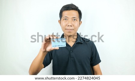 Indonesian people holding Indonesian identity cards (KTP : Kartu Tanda Penduduk).