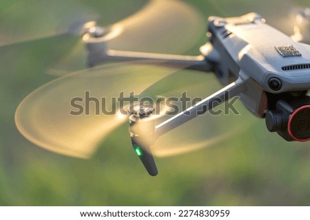 Drone quadcopter with digital camera and fast rotating propellers flying taking video and pictures Royalty-Free Stock Photo #2274830959