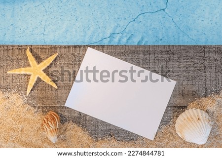 Invitation card without inscription seen from above on a wooden pavement above a pool with a starfish. Atmosphere vacations in summer.	