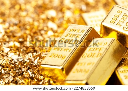 Gold bars on nugget grains background, close-up Royalty-Free Stock Photo #2274853559