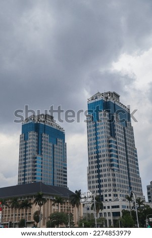 low angle view of exterior of twin blue skyscrapers under overcast sky. copy space