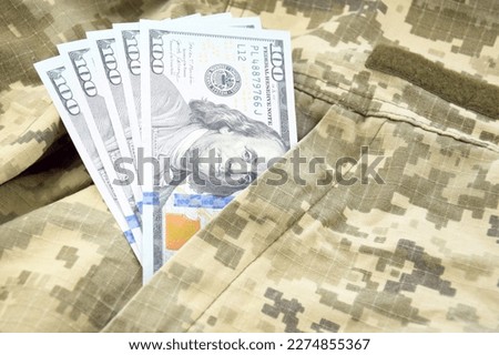 American dollars banknotes on military pixel background.