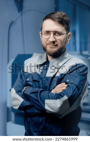 Portrait young man Worker of industry factory background CNC machinery, blue color.
