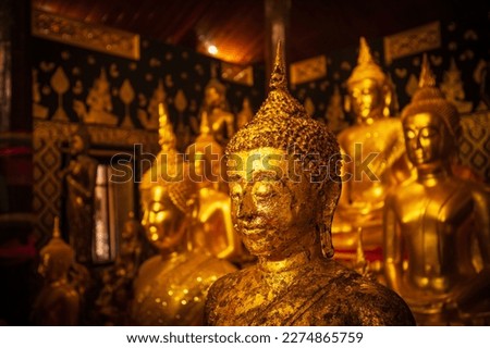 Golden group buddha faces statue meditation sitting with a Golden Buddha background up down and sitdown. Buddha in meditation posture during seated.