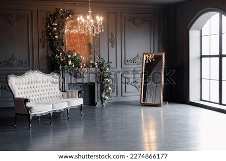 Black room interior with a vintage sofa, chandelier, mirror and fireplace decorated with flowers Royalty-Free Stock Photo #2274866177