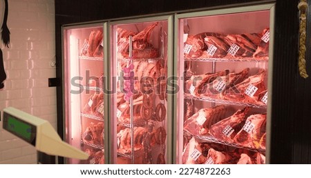 Beef steaks in dry aged meat aging in refrigerating cabinet. Dry aging meat in cold storage. Dry-aged cuts of raw meat, aged beef for steaks. Royalty-Free Stock Photo #2274872263