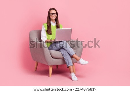 Full length photo of optimistic cheerful girl with straight hairdo dressed green vest writing on laptop isolated on pink color background