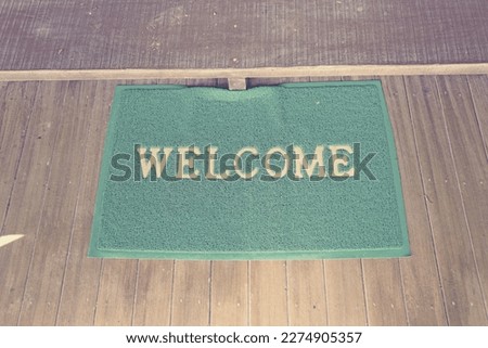 green welcome mat on floor.