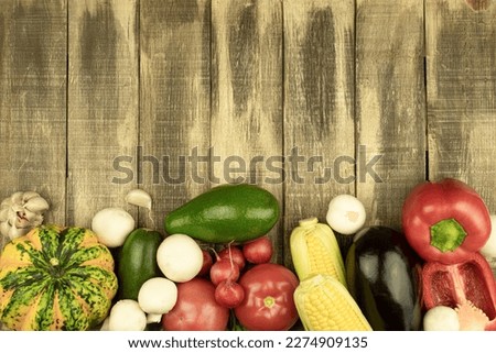 Fresh vegetables are laid out on a wooden table. Vegetables are laid out on a rough wooden table, top view. Place for the test