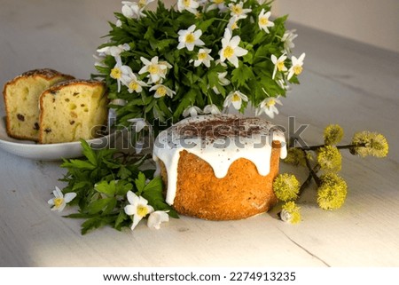 Traditional ukrainian easter cake with marshmallow glaze. Easter table with traditional dessert and spring flowes. Easter bunny.
