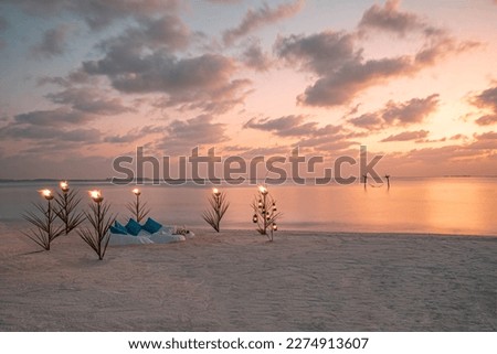 Sand table setup for dining on sunset beach. Romantic destination dining, couple anniversary romance celebration. Love arrangement togetherness dinner on island shore. Amazing sky sea view golden sky Royalty-Free Stock Photo #2274913607