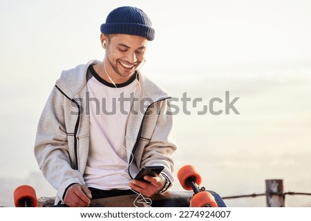 Skateboarder, phone and man streaming music, audio or podcast online and relax after skating with mockup and texting. Skater, skateboard and person listening to mobile radio in sunset on social media